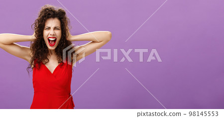Ex-boyfriend spoilt woman formal event being outraged and pissed yelling in fury holding hands on curly hair grimacing from anger standing over purple background in stylish evening red dress Ex-boyfriend spoilt woman formal event being outraged and pissed yelling in fury holding hands on curly hair grimacing from anger standing over purple background in stylish evening red dress 98145553