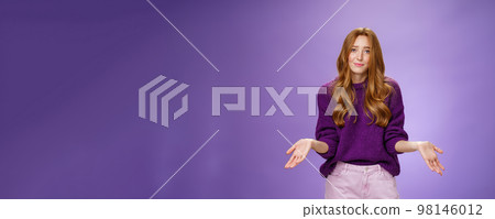 Who cares chill I not know. Portrait of clueless and unbothered cute redhead female in purple sweater smirking in sorry and shrugging with hands sideways being questioned and puzzled to answer Who cares chill I not know. Portrait of clueless and unbothered cute redhead female in purple sweater smirking in sorry and shrugging with hands sideways being questioned and puzzled to answer 98146012