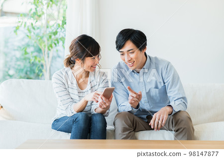 A young couple looking at a smartphone 98147877