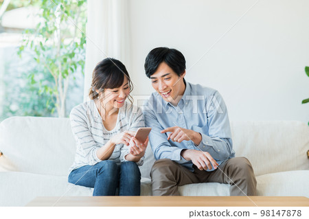 看智能手機的一對年輕夫婦 98147878