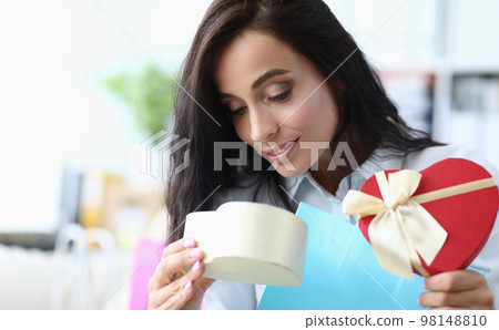 Beautiful woman opens gift box. Gift from a loved one 98148810