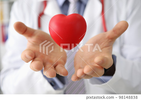 Hands of cardiologist doctor hold heart in air Hands of cardiologist doctor hold heart in air 98148838