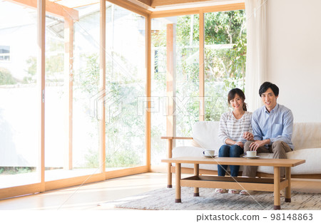 一對年輕夫婦在客廳裡放鬆 一對年輕夫婦在客廳裡放鬆 98148863