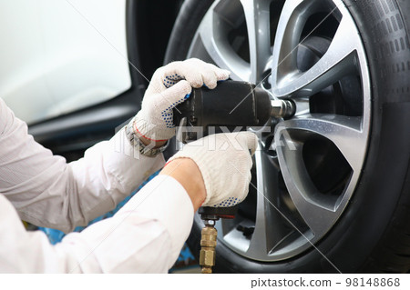 Garage master unscrews nuts to broken wheel of car 98148868