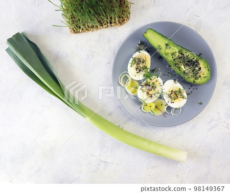 Salad of microgreens, avocado, boiled eggs, leek and arugula, on a plate, top view, natural ingredients, healthy food 98149367