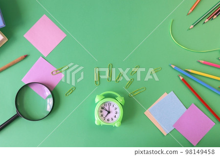 Stationery, alarm clock, books on a background of pastel colors of multi-colored paper, back to school, education, schoolchild study table, copy space, top view 98149458