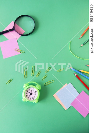 Stationery, alarm clock, books on a background of pastel colors of multi-colored paper, back to school, education, schoolchild study table, copy space, top view 98149459