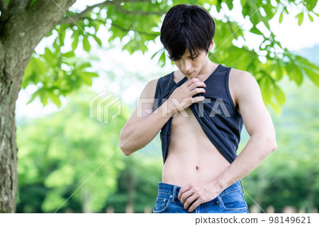 一個外國男人在樹蔭下檢查他的腰 98149621