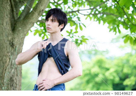 A foreign man checking his waist in the shade A foreign man checking his waist in the shade 98149627