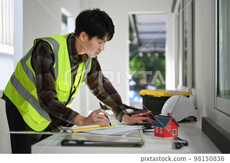 Engineers man working with blueprint, examining plans at construction site. Industry, Engineer, construction concept 98150836