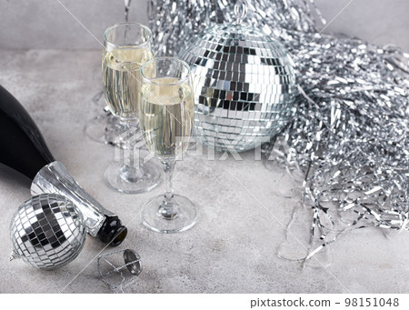 Glass of champagne with disco ball. 98151048