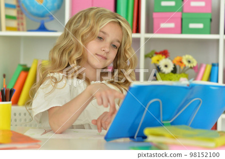 little girl studying at home at the table 98152100