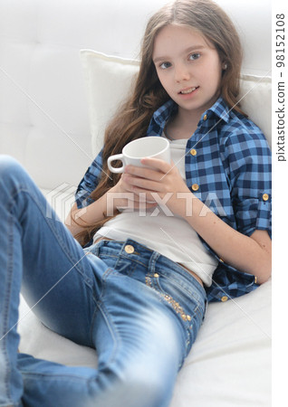 Portrait of girl with cup of tea sitting  98152108