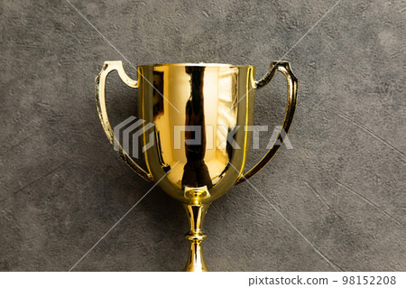 Simply flat lay design winner or champion gold trophy cup on concrete stone grey background. Victory first place of competition. Winning or success concept. Top view copy space 98152208
