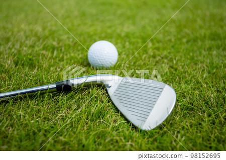Golf clubs and ball on a green grass, background Golf clubs and ball on a green grass, background 98152695