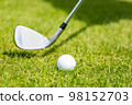 Close-up of the white golf ball on a stand on a green field 98152703