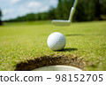 Hole on the golf course, next to a white ball 98152705