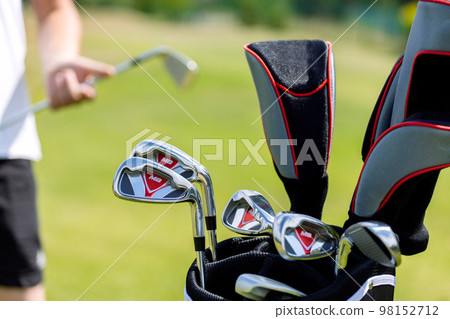 Black golf club bag on the golf course against a background of green grass. High quality photo 98152712