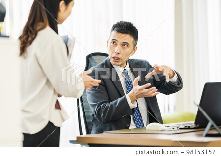 Businessman talking to colleague in office 98153152