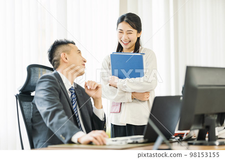 Career woman talking to her boss in the office Career woman talking to her boss in the office 98153155