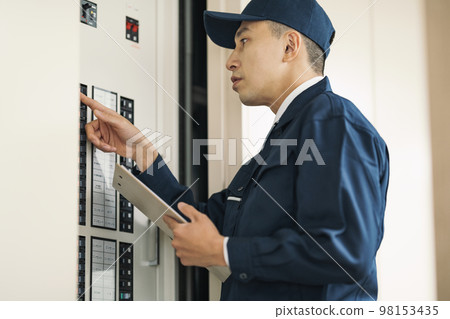 Electrician checking the distribution board 98153435