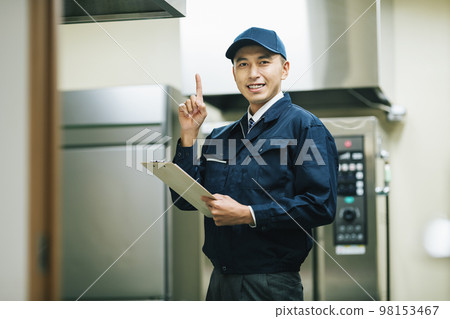 Men in work clothes inspecting equipment 98153467