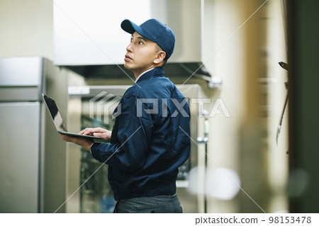 Maintenance personnel inspecting equipment 98153478