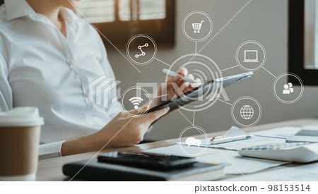 Business women hand working with tablet and laptop computer with documents on office desk in modern office. 98153514