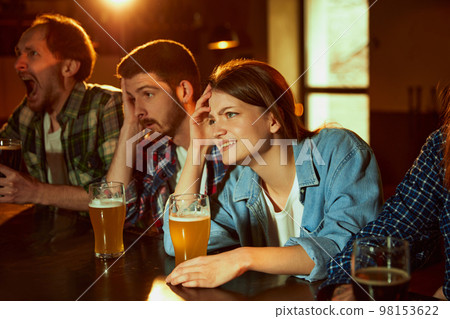 Group of young people, friends meeting at pub to watch sport match translation. Losing game. Stressful emotions. Group of young people, friends meeting at pub to watch sport match translation. Losing game. Stressful emotions. 98153622