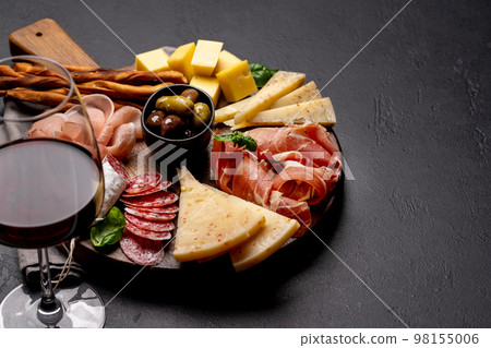 Antipasto board with various meat and cheese snacks Antipasto board with various meat and cheese snacks 98155006