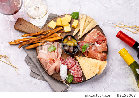 Antipasto board with various meat and cheese snacks Antipasto board with various meat and cheese snacks 98155008