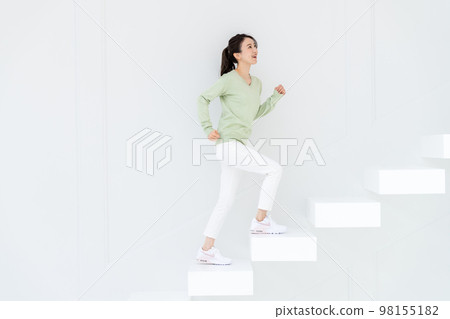 Young young woman walking up the stairs 98155182