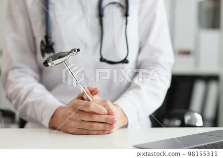 Doctor neurologist with hammer in hands in clinic 98155311