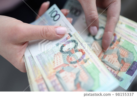 One hundred Belarusian rubles banknotes in female hands 98155337