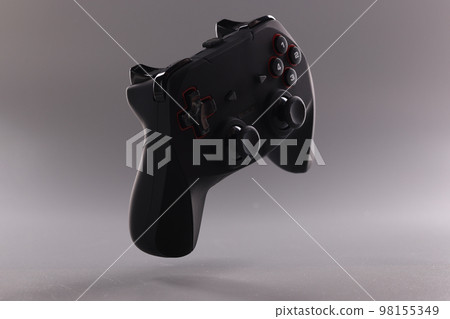 Black gamepad or game joystick on gray background in air 98155349