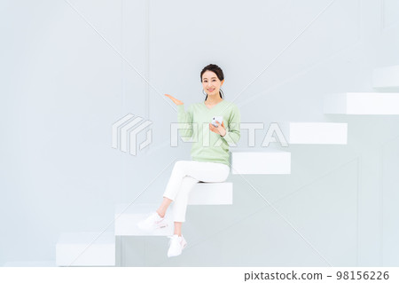 年輕女子在樓梯上看智能手機 98156226