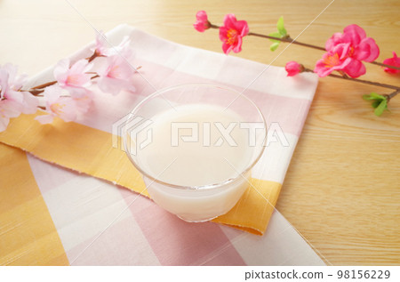 將甘酒倒入玻璃杯中的場景 櫻花和梅花以及粉色方格伊勢棉 98156229