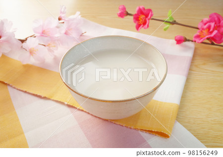 將甘酒倒入陶器中的場景 櫻花和梅花以及粉色方格伊勢棉 98156249