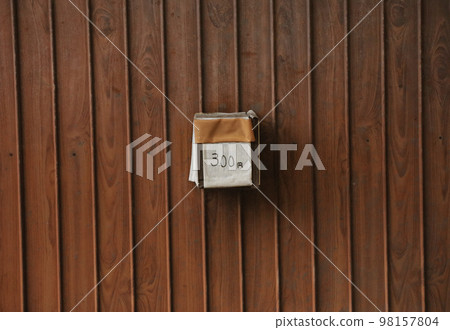 A handmade coin purse for unmanned sales attached to a wood-grain tin plate 98157804