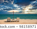 Beach chairs on the sand beach with dramatic sky at sunset 98158971