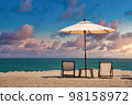 Beach chairs on the sand beach with dramatic sky at sunset 98158972