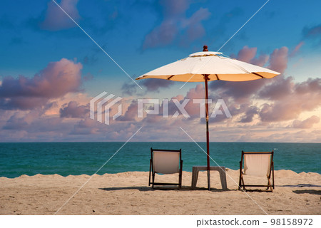 Beach chairs on the sand beach with dramatic sky at sunset 98158972