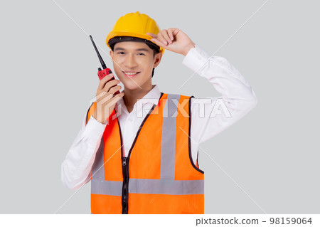 Portrait young asian man is engineer wearing helmet standing and using radio for speak. 98159064