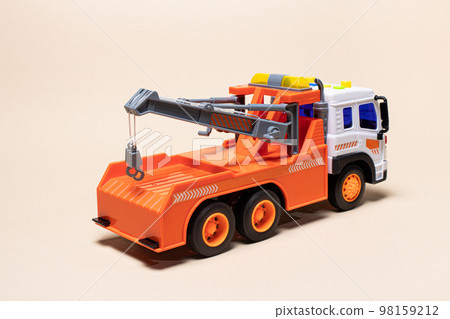 Toy orange tow truck on beige background. Children's car for loading and transporting cars. 98159212
