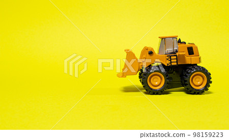 Toy typewriter tractor bulldozer on a yellow background. Toy for children Toy typewriter tractor bulldozer on a yellow background. Toy for children 98159223