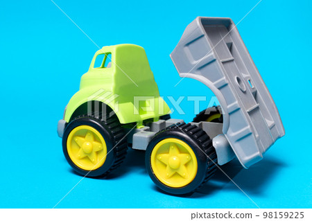 Toy truck car on a blue background - construction equipment for children. Bright children's plastic toys, dump truck childhood. Copyspace banner place for text. Toy truck car on a blue background - construction equipment for children. Bright children's plastic toys, dump truck childhood. Copyspace banner place for text. 98159225