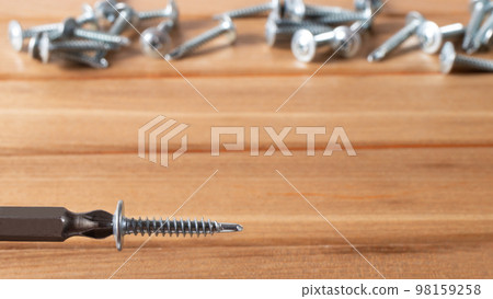 A screwdriver and self-cutters on a brown wooden background. Building tools to repair the house. A screwdriver and self-cutters on a brown wooden background. Building tools to repair the house. 98159258