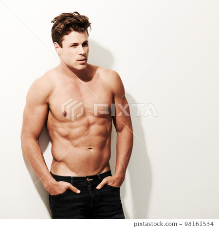 Manly and muscular. A handsome male with no shirt on with his hands in his pockets. 98161534