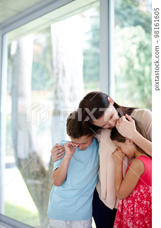 Grieving as a family. Shot of a family supporting each other in their grief. Grieving as a family. Shot of a family supporting each other in their grief. 98161605