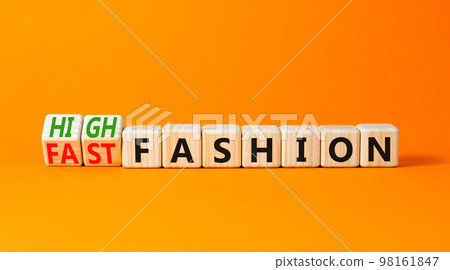 Fast or high fashion symbol. Concept words Fast fashion and High fashion on wooden cubes. Beautiful orange table orange background. Business fast or high fashion concept. Copy space. 98161847
